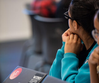 Back view if student sitting behind a computer looking away.